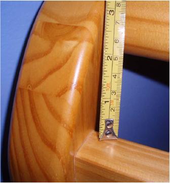 Picture of recalled crib, correctly assembled, with ruler showing gap of only about 2 inches