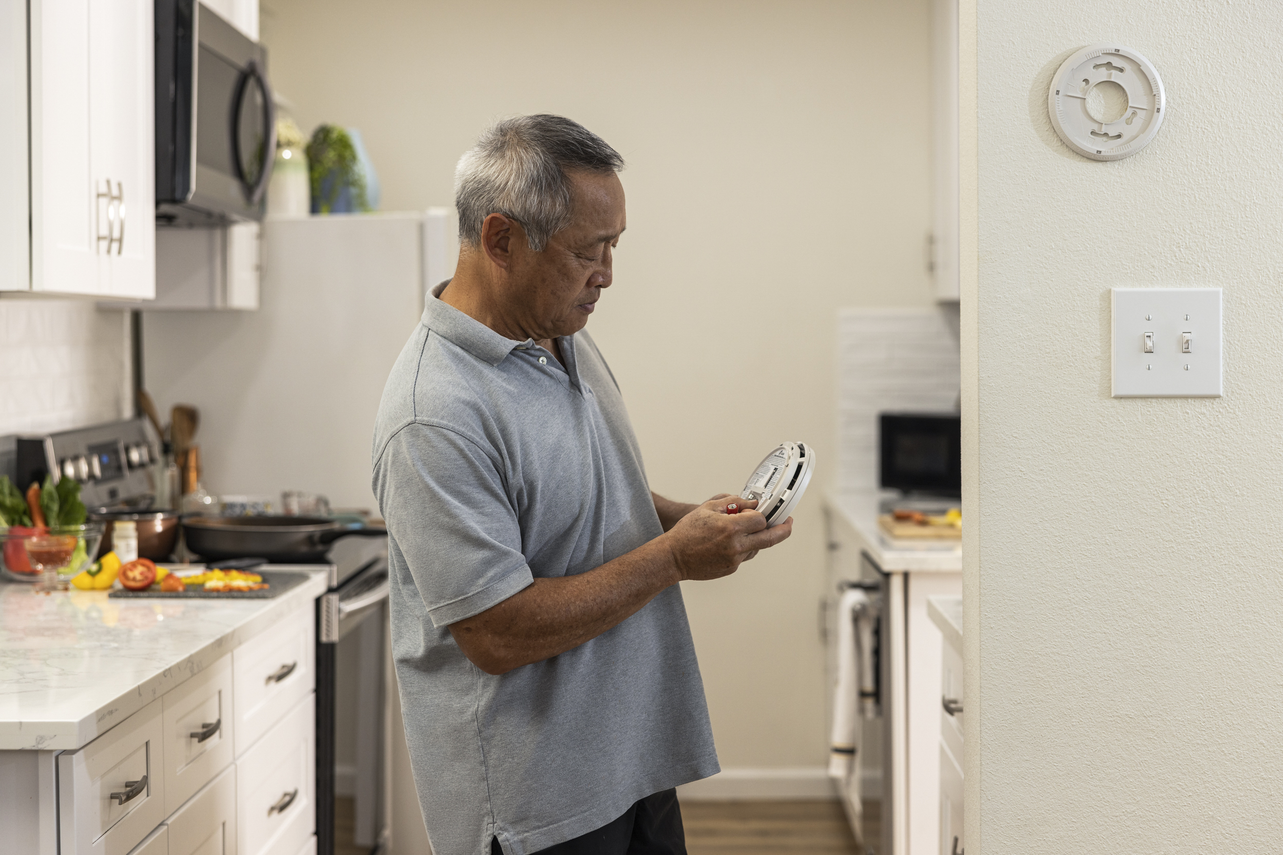 Fire Safety - Person with a prosthetic leg checking their smoke alarm batteries.