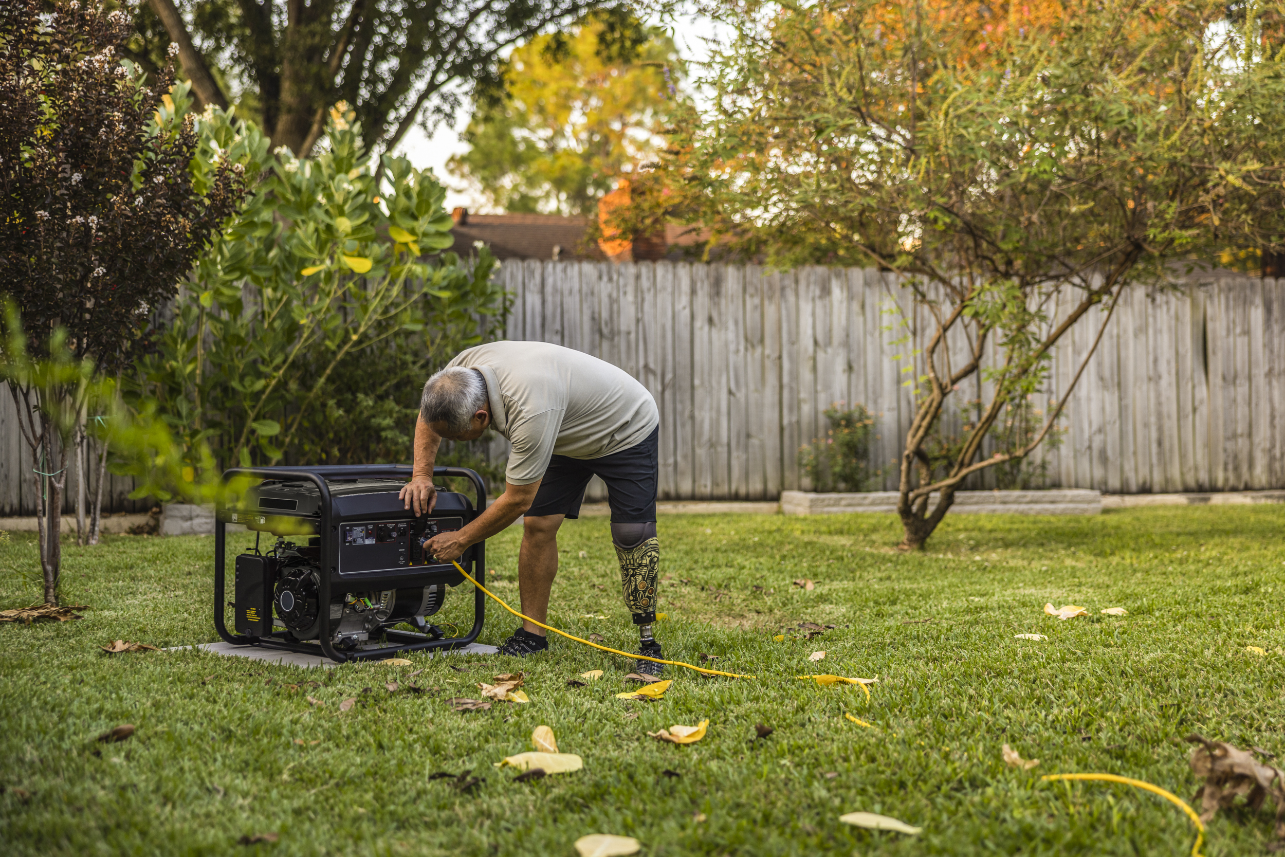 Carbon Monoxide Safety - Person with a prosthetic leg safely installing a portable generator.