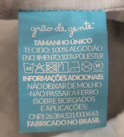 Grão de gente tag sewn onto cloth cover