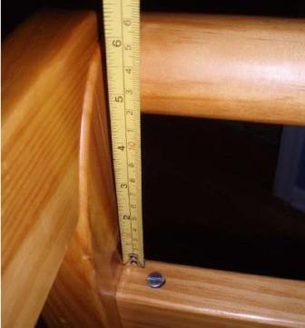 Recalled crib, incorrectly assembled, with a ruler showing a gap of about 5 inches