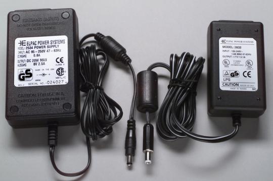 A recalled ELPAC AC adapter with an angled connector tip (left) and the replacement ELPAC AC adapter (right)