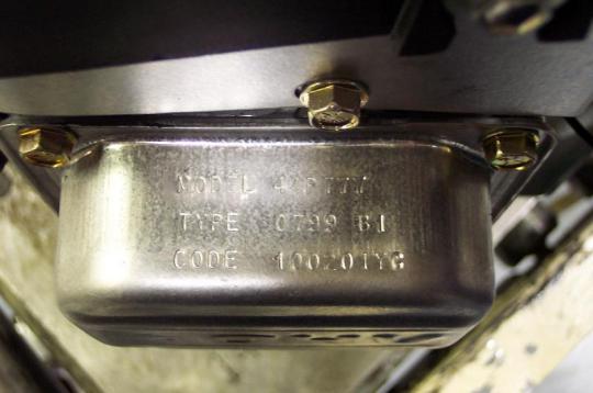 The valve cover is stamped with the model number at the top and date code at the bottom