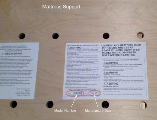 Model number and manufacture date are on the warning label attached to the crib's mattress support.