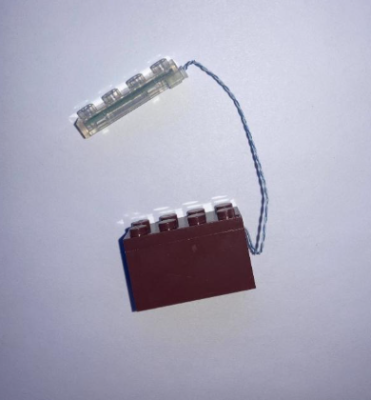 Recalled Cubimana Treehouse Building Set - brown building piece with a LED light that uses a button cell battery.