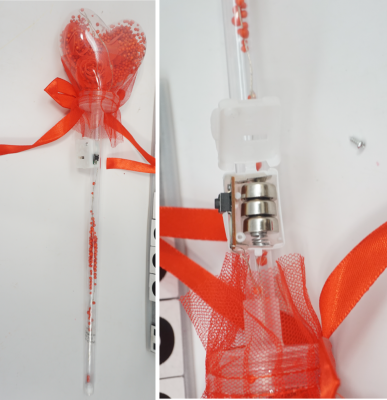 Recalled light-up heart balloon flower (Item No. 777-1) – Wand and close up showing accessible button cell batteries. 