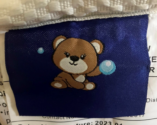 Dark blue tag with cartoon bear found on recalled mattress