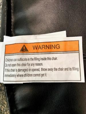 Warning label located in the seam of the Target Room Essential leather pouf ottoman