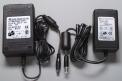 A recalled ELPAC AC adapter with an angled connector tip (left) and the replacement ELPAC AC adapter (right)