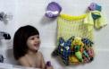Girl Smiling at Toy Netting in Bathtub